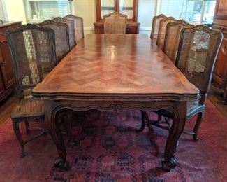 Amazingly large French walnut dining table, with extendable leaves on both ends, set of 12 chairs (pair of arms, 10 sides), matching buffet and bonnetiere.           
The French table measures 8' 6"L x 3' 8" W x  2' 6"T, with 27" extensions on each end.