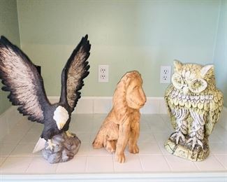 very large eagle, owl figures and a wooden carving of a lion