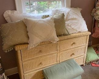 Wicker dresser covered with white linen pillows
