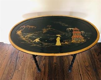 ITEM 15: OVAL LACQUER TRAY TABLE on a STAND decorated with a Japanese style landscape. Dimensions: 33''W x 21"D x 26"H. The wooden top can be also used as a tray or as decoration to hang on a wall.
