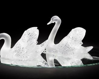 14
A Pair Of Lalique Art Glass Swans
Fourth-quarter 20th Century
Each with acid etched signature: Lalique (R) France
The pair of frosted and clear glass swans one with head raised, one with head lowered set on a mirrored oval plateau with etched waves, 3 pieces
Overall: 9.75" H x 33" W x 22" D
Estimate: $2,000 - $3,000
