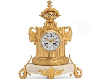 281
A French White Marble And Gilt Bronze Clock
Late-19th/early-20th Century
Stamped: 1821/6
The white dial with Arabic and Roman numerals set in a bronze columnar-shaped body with rams heads, ribbons, and laurel leaf decoration under an acorn finial on a white marble base and three gilt bronze scrolled feet visible
21.5" H x17.5" W x 9" D
Estimate: $1,000 - $1,500