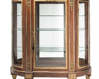 284
A French Gilt-Bronze Vitrine Cabinet
Second-quarter 20th Century
The egg and dart crest over a sun king frieze over a glazed cabinet, issuing three glass shelves raised on squat gilt-bronze mounted feet
75.25" H x 68.25" W x 18.5" D
Estimate: $4,000 - $6,000