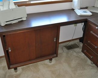 Administrator Alma mid-century walnut desk 60” x 30” and 28.5” tall (out of High Point, North Carolina in the 1960’s. The company was bought out by Heworth in the 1990s. The patent on this design was filed in 1964.  It has a laminate top which was probably used to ensure durability. Eames era “design” of the legs.), 
Administrator Alma mid-century walnut return/credenza 77” x 18” and 28.5” high, Corona Coronamatic 1200 electric typewriter with case, MacIntosh SE vintage computer keyboard and manuals, MacIntosh vintage printer