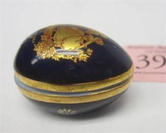 Small egg form porcelain trinket box. Cobalt blue glaze.  gold transfer image of an 18th century courting couple.  Marked Limoge France. 1" by 1 3/8"