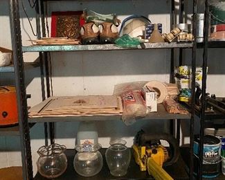 75. Three shelves Of goodies.  Old boat light, drills, paint! Hummingbird feeders and more.  
THIS INCLUDES THE THREE BLACK SHELVES ON RIGHT.  NOT FAR GREY LEFT ONE. $$100