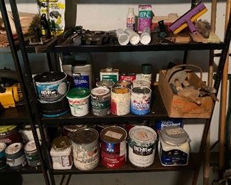 75. Three shelves Of goodies.  Old boat light, drills, paint! Hummingbird feeders and more.  
THIS INCLUDES THE THREE BLACK SHELVES ON RIGHT.  NOT FAR GREY LEFT ONE. $$100