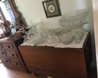 Another drop leaf table, punch bowl On stand with cups, more clear glass