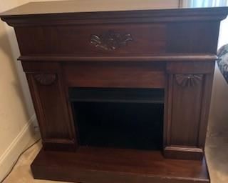 Freestanding Fireplace, dark walnut, carved details. Minor damage on edges of hearth portion. NOT ELECTRIC. $300.00                                                                  
Debit and Credit Accepted.    
