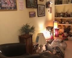 A variety of beautiful lamps and lampshades, leather armchair, leather ottoman, art, occasional tables