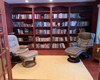 Library filled with books and Leather Recliners 