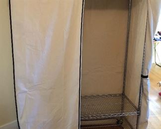 Rolling metal clothes rack with removable canvas cover (48”W, 69”H, 18” D) Cover unrolls & zips down the front