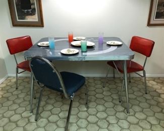 Formica table & 3 chairs. One red chair has damage.