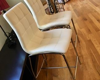 side view of 2 of 4 chrome and white leather counter stools
