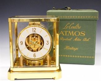 A mid 20th century LeCoultre 528-6 Caliber Atmos clock.  Perpetual movement runs on atmospheric pressure, with silvered chapter ring and Arabic numerals in a Brass and glass case, with original box and instruction book.  Light surface corrosion, running when cataloged.  9 1/4" high.  ESTIMATE $300-400