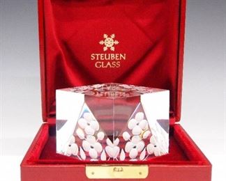A Steuben Crystal Cube.  Cube form sculpture entitled "Spring Crystal" consists of clear and etched crystal with floral motifs; model 1044, designed by Peter Schulze and Bernard X. Wolff, 1975.  Signed "Steuben" at the underside, includes original presentation case and box.  Very light surface scratches, both boxes show some wear.  3 1/8 x 3 1/8 x 3 1/8" high.  ESTIMATE $200-400