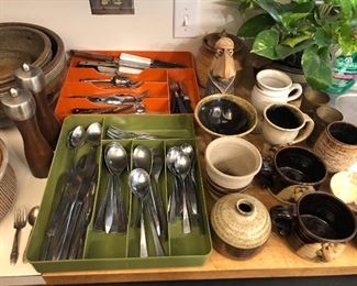 Silverware and fun selection of mugs, cups and bowls, including mugs with faces and feet.