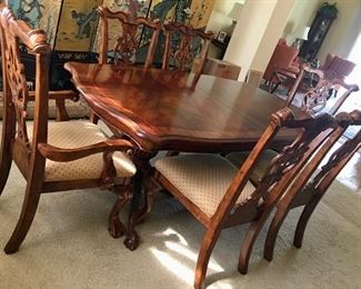 Chippendale style dining table with 8 chairs (6 shown). Two are host chairs with arms. Two 16" leaves. Full table pads. 