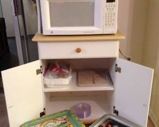 General Elictric microwave, microwave stand with drawer and two door storage. Three vintage TV trays ( Star Wars, Cabbage Patch and greenery)