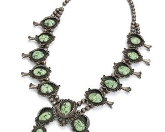 2
A Squash Blossom Necklace
Apparently unsigned
Centering a naja set with green turquoise in a molded leaf frame flanked by complementary blossoms
26" L x 3.25" H x 3.25" W
268.5 grams
Estimate: $400 - $600