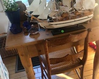 More of the antique pine table, with an antique pine and rattan chair