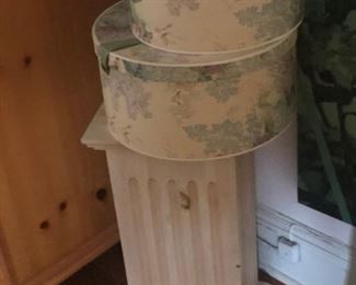 A pedestal with some hatboxes