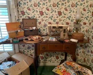Vintage Singer Sewing Machine in cabinet with bench, large collection of sewing supplies, sewing boxes, and sewing books 