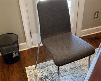 One of two gray upholstered modern chrome office chairs 