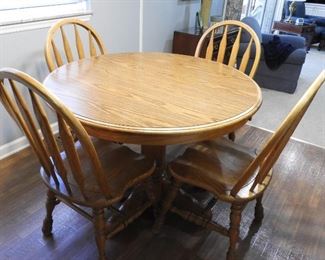 Oak kitchen table 42 inch diameter,  two 12' leaves, 4 oak chairs