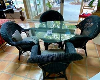Lot 3156. $395.00. Vintage Black Wicker Round Table With Glass Top and 4 Chairs with cushions. Has hole for an umbrella, however, this was described to us as an indoor wicker set.  Still, an umbrella would look cute even indoors!    Cushions are Polkadot and in good shape.  