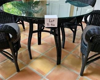 Lot 3156. $395.00. Vintage Black Wicker Round Table With Glass Top and 4 Chairs with cushions. Has hole for an umbrella, however, this was described to us as an indoor wicker set.  Still, an umbrella would look cute even indoors!    Cushions are Polkadot and in good shape.  