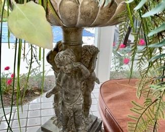 Lot 3158. $200.00. Becket Water Gardening Statue Fountain with 3 Cherubs, made of resin, filled with faux floral, shown as a planter featuring sunflowers, lemons, and greenery.  22" Tall x 16" Round  - we didn't attempt to measure the floral display.   