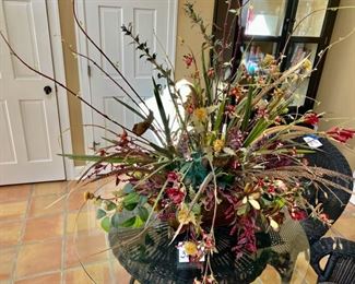 Lot 3216. $175.00  Unique Large Scale floral centerpiece in bronze colored  container with Faux flowers and exotic bird feathers. the base is 16'L x 8"W x 9" H,  Floral 48"W x 42"H		 