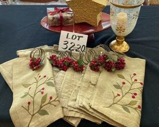 Lot 3220. $32.00  8 Crate and Barrel Gold napkins and 8 Crate and Barrel  holly napkin rings ; Melrose International Co. red pedestal plate (12.5" x 8' x 3.5" t); Gold star shaped box with potpourri and a Holiday star footed hurricane.		