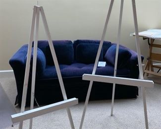 Lot 3276. $150.00 Navy Blue, velveteen, single seat cushion love seat.  This piece is slightly faded but would be great with a slipcover or Afghan.  Perfect for a small bedroom or living area.  Easels are Lot 3357.