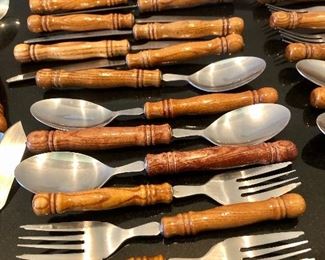 Lot 3229. 	$175.00  Great set of wood-handled flatware - stainless.  Great shape, feels "right" or ergonomically correct in your hand. Set includes: 8 each - knives, soup spoons, salad forks; 7 regular dinner forks; 2 large serving spoons, 1 each slotted serving spoon, large meat fork, ladle, sugar spoon & master butter knife.	