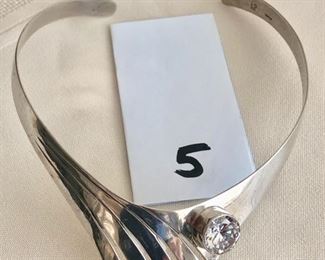 $125.00.   Exquisite artist signed sterling silver collar necklace set with a very large sparkling CZ.   The collar is expandable and is best suited to a small to medium necklace.