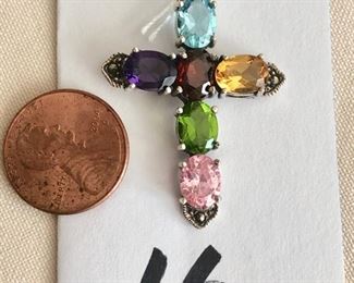 $30.00.   Sterling silver, marcasite, amethyst, garnet, citrine (yellow & green), blue topaz and pink crystal cross.  Nice size bale on top to accommodate various chains.  Cross measures 2" long with bale.