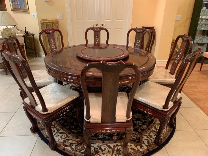 Oriental teakwood dining table and 8 side chairs. 20/21 C. Custom made with Mother-of-pearl inlay and center Lazy-Susan. In the "Ming" style, the chairs with pad cushion seats. $1500
