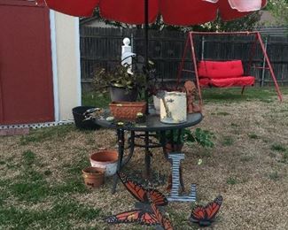 Garden table with umbrella, plants, and lots of decorations