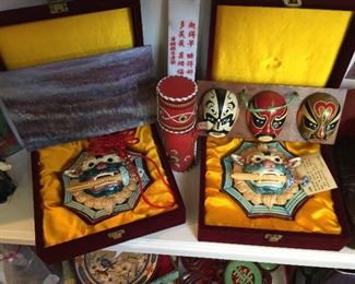 A close look at two Lucky Lions with sword in mouth, masks leather container
