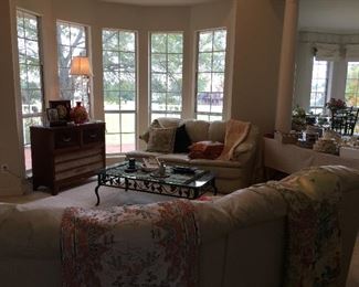 The upper level of the house. Vintage record/radio cabinet, Cream leather sectional, metal/glass coffee table, silk textiles