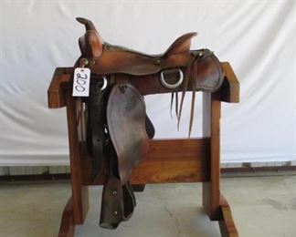 200	

Cowboy Ranch Saddle
Western Ranch Saddle.  15 1/2 inch seat.  Kids size safety tapadero stirrups.  Saddle complete with latigo, cinch and string ties.  Saddle has vintage string conchos.  Saddle is in using condition.