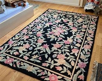 Large floral hooked area rug.