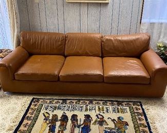 Three seat leather sofa & Egyptian motif rug.