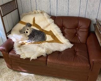 Tufted leather loveseat and alpaca throw.