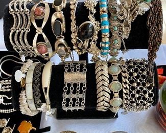 Many beautiful silver bracelets.