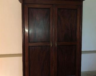 American Neoclassical Santo Domingo mahogany linen press, early 19th century, in the French style, with cypress as the secondary wood, with stepped molded cornice, double paneled doors, and short turned legs
