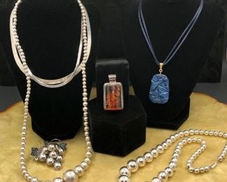 Sterling silver jewelry including amber pendant and large carved lapis pendant.