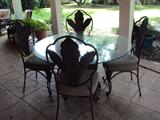 Dining table base of composite material carved acanthus leaves with 4 iron chairs with tobacco leaf back .  Glass top is beveled and scalloped